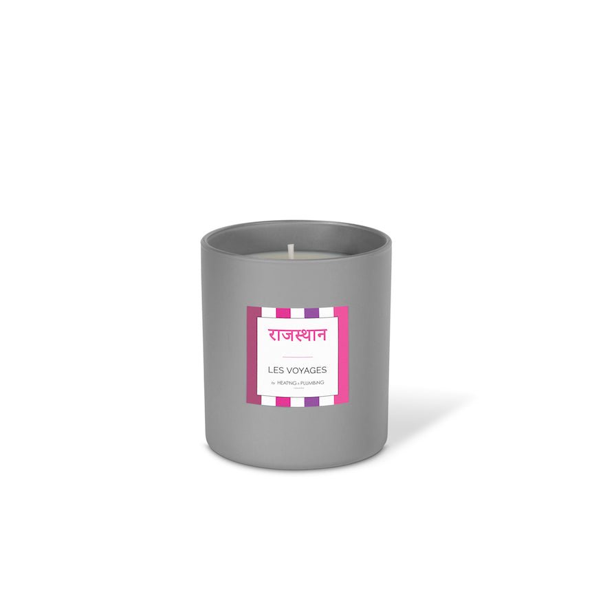 Grey candle with a striped label on a white background
