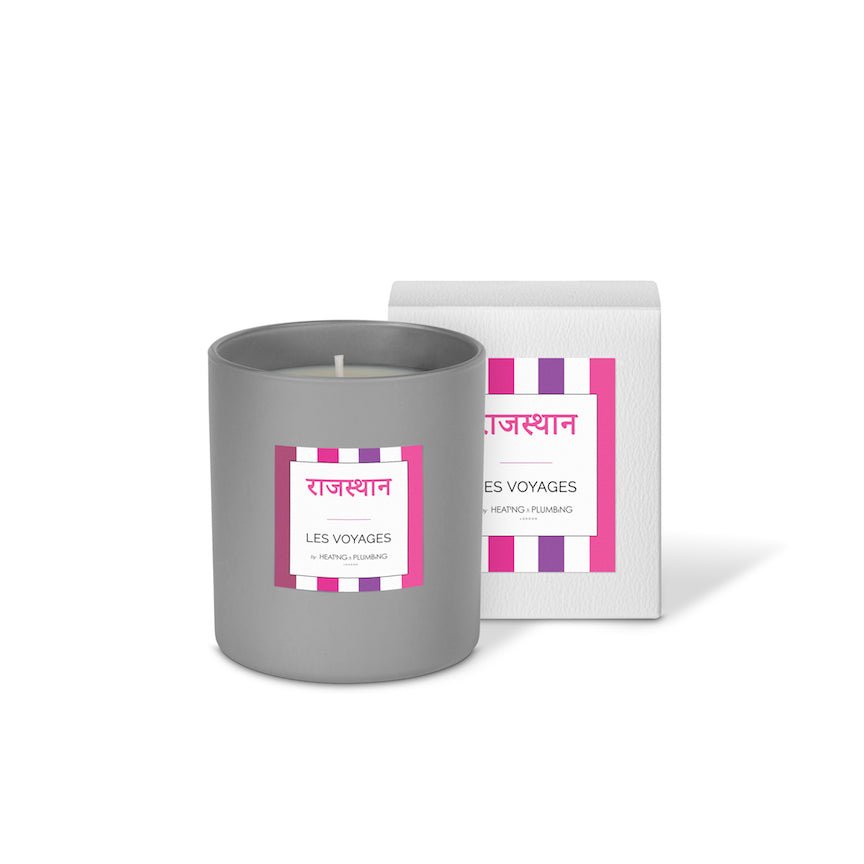 Grey candle with a label and packaging on a white background