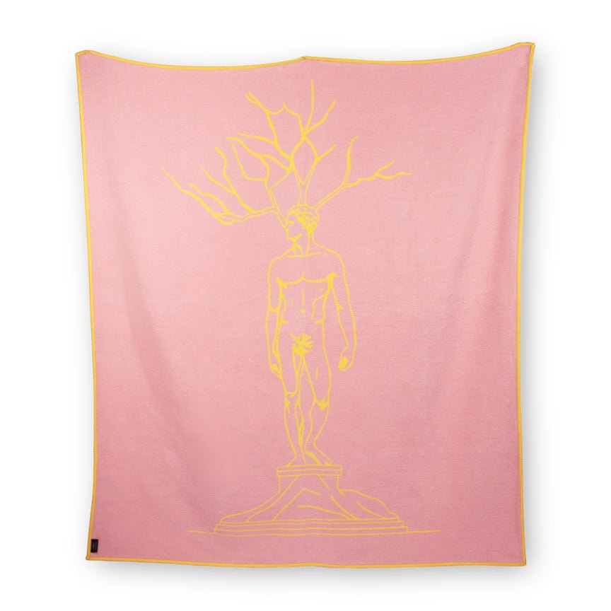 Pink blanket with yellow outline of a statue design on a white background