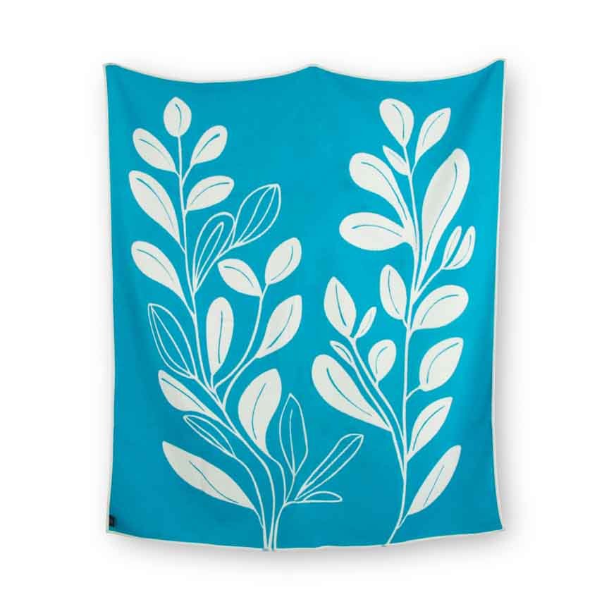 Turquoise blanket with white leaf patterns on a white background