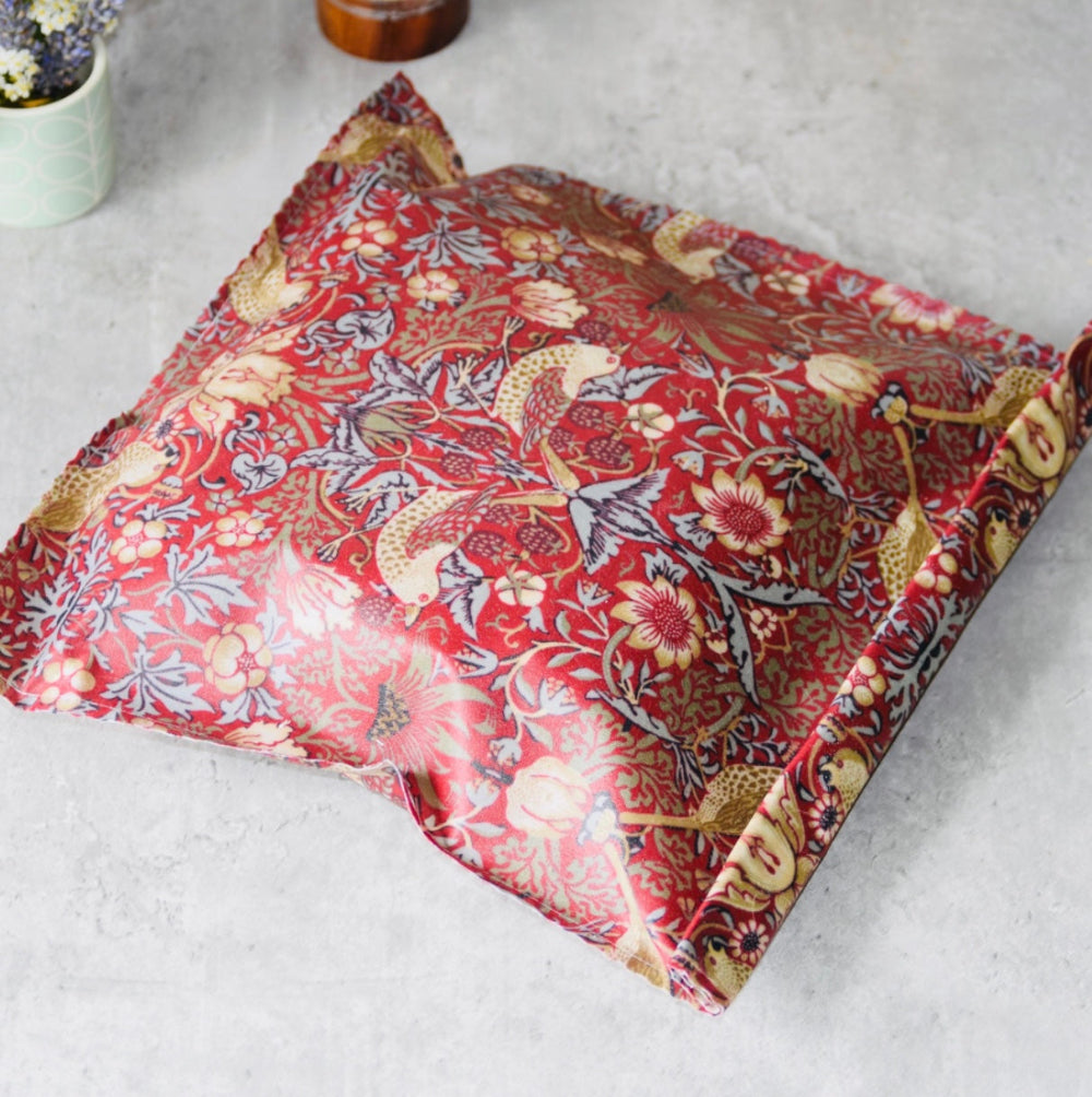 Floral-patterned william morris strawberry thief beeswax wrap on a light grey surface