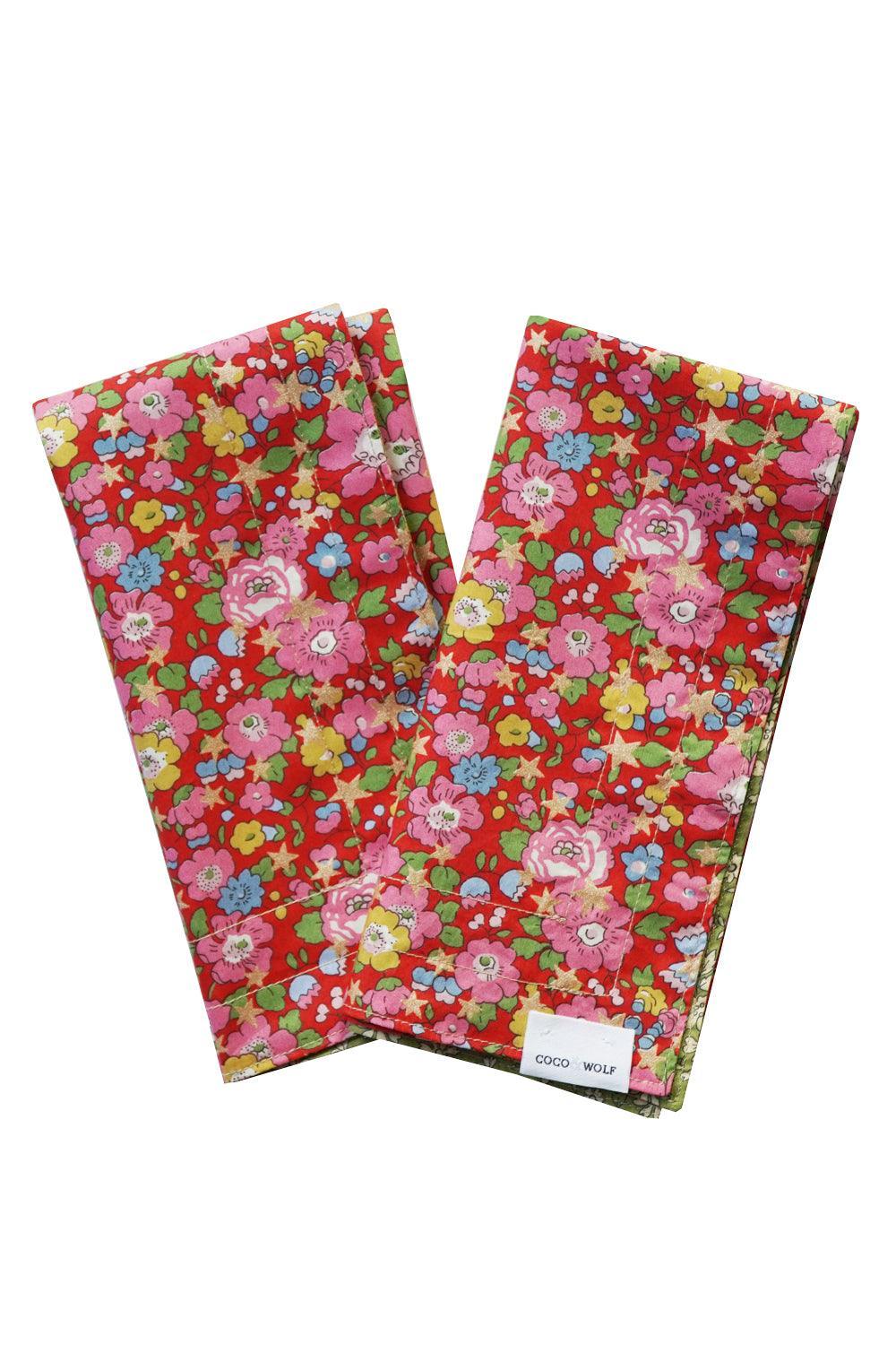 Two floral-patterned liberty napkins with a visible brand label Coco + Wolf on a white background