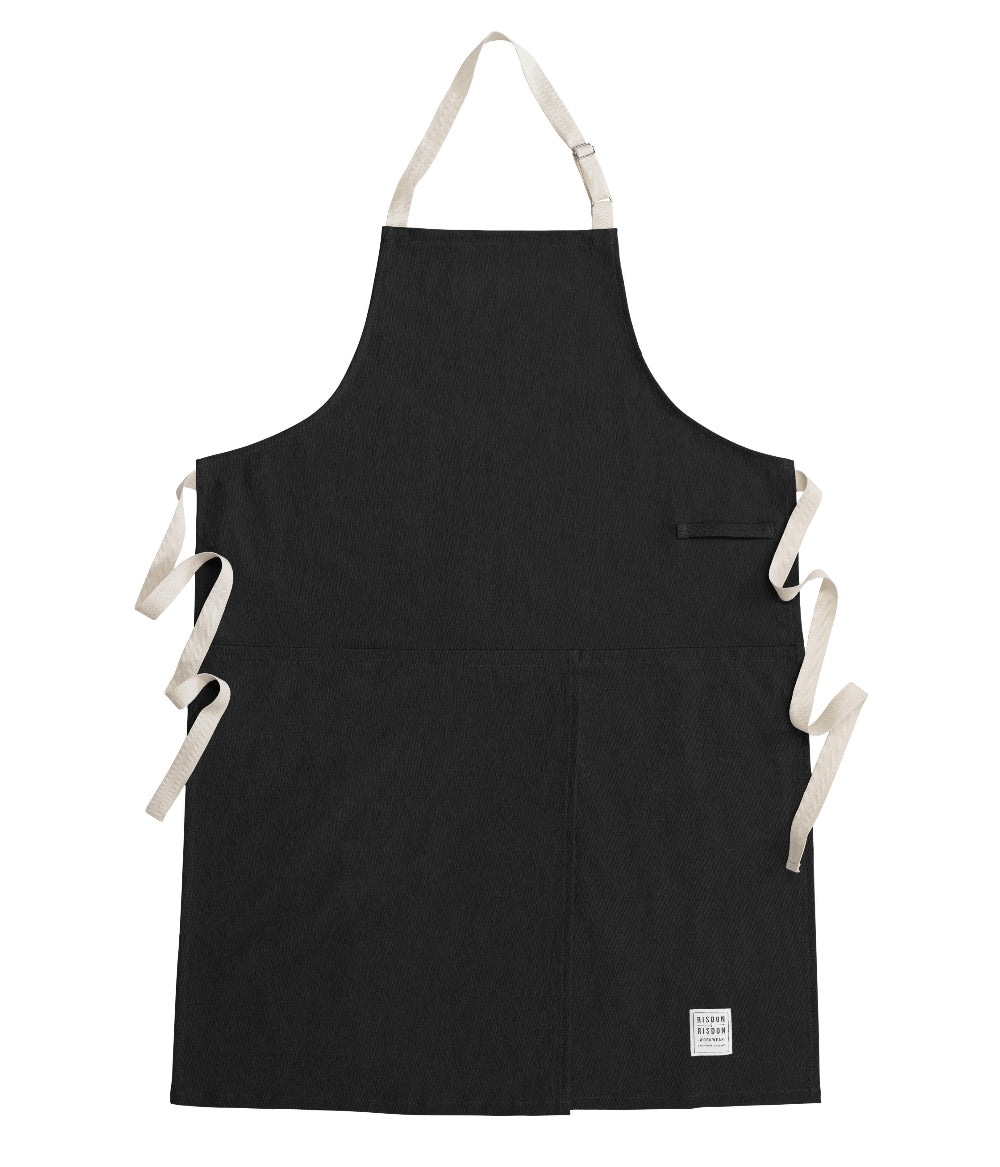 Black potters apron with white straps on a white background