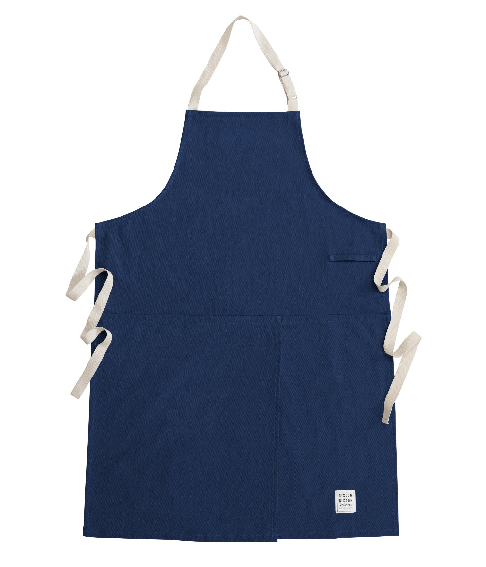 Navy blue potters apron with white straps on a white background