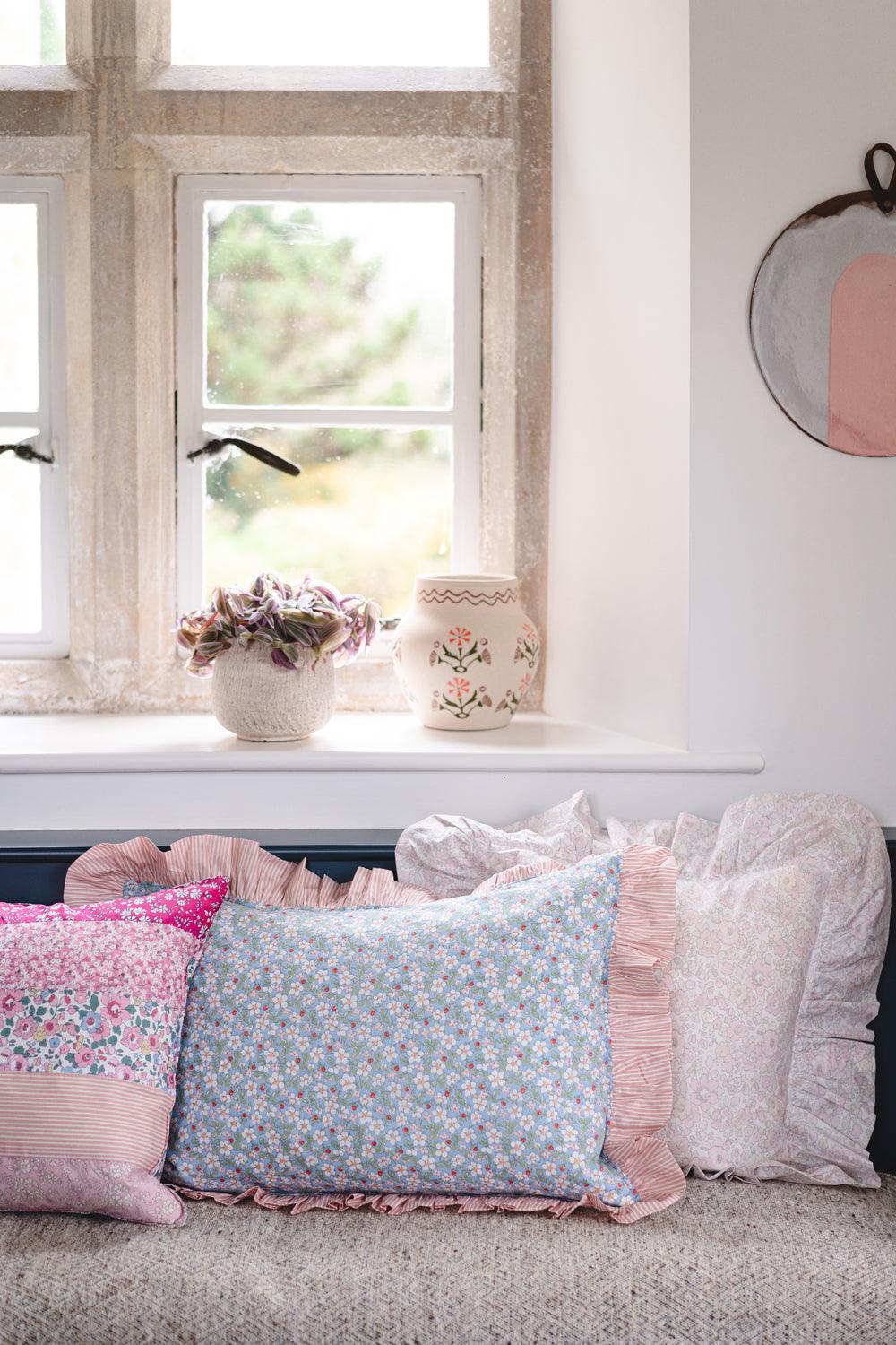 Decorative pillows on a sofa with a window in the background