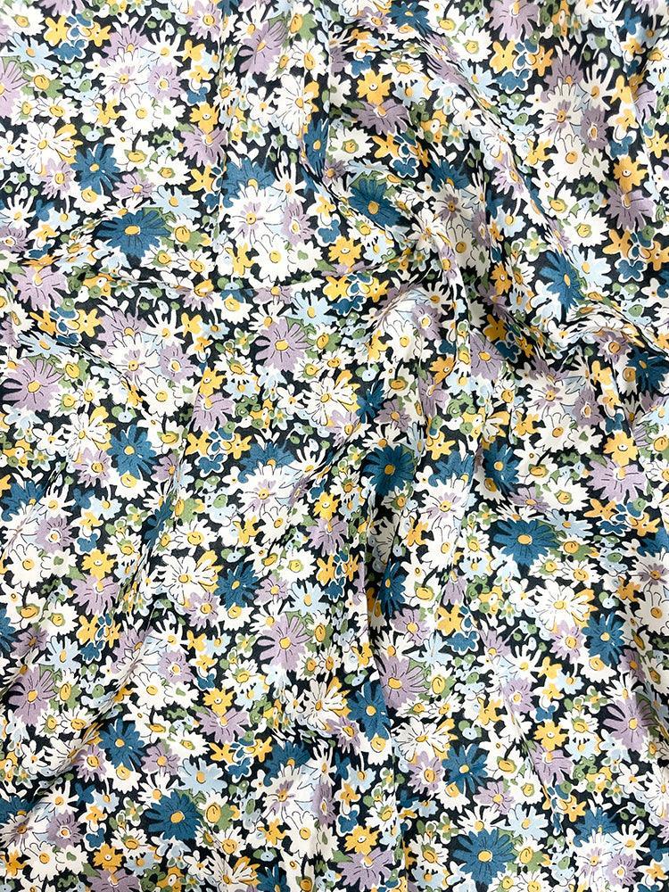 Floral patterned fabric with small flowers in various colors on a black background