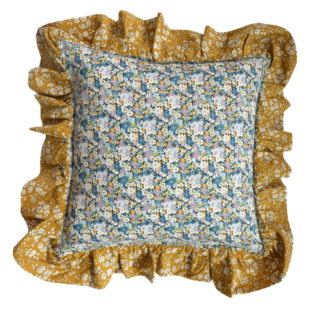 Floral pillow with ruffled mustard coloured edges on a white background