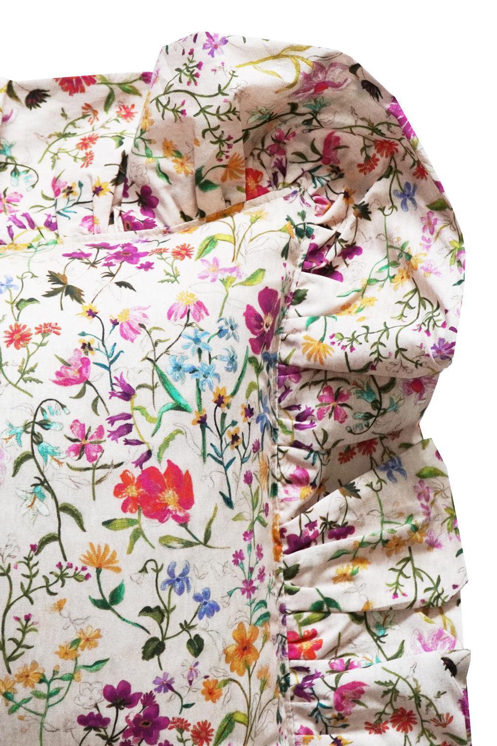 Floral patterned ruffled cushion edge with colourful flowers on a white background