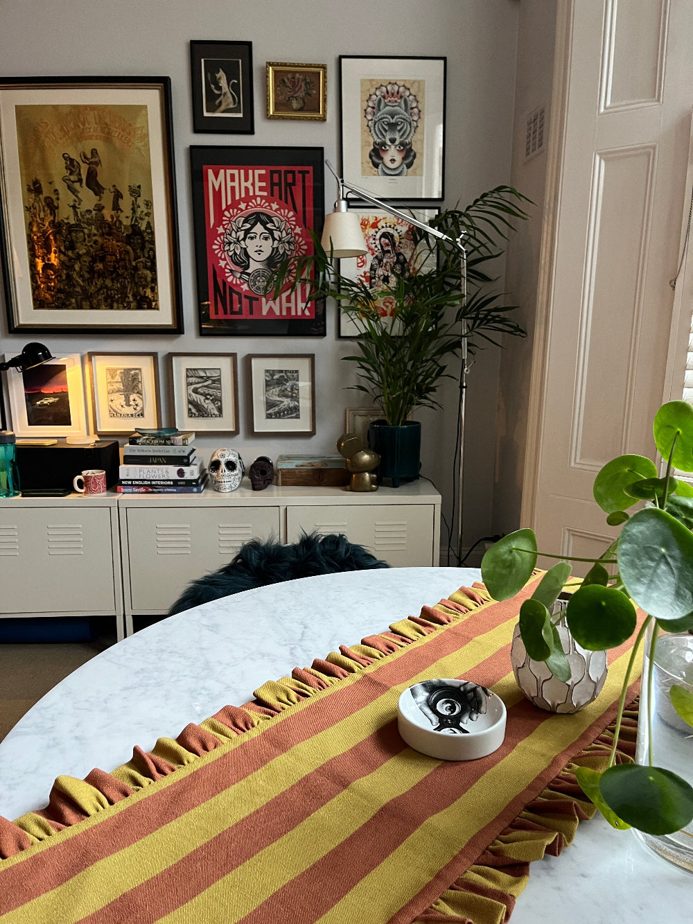 Rust and mustard striped table runner with decorative objects on a round table