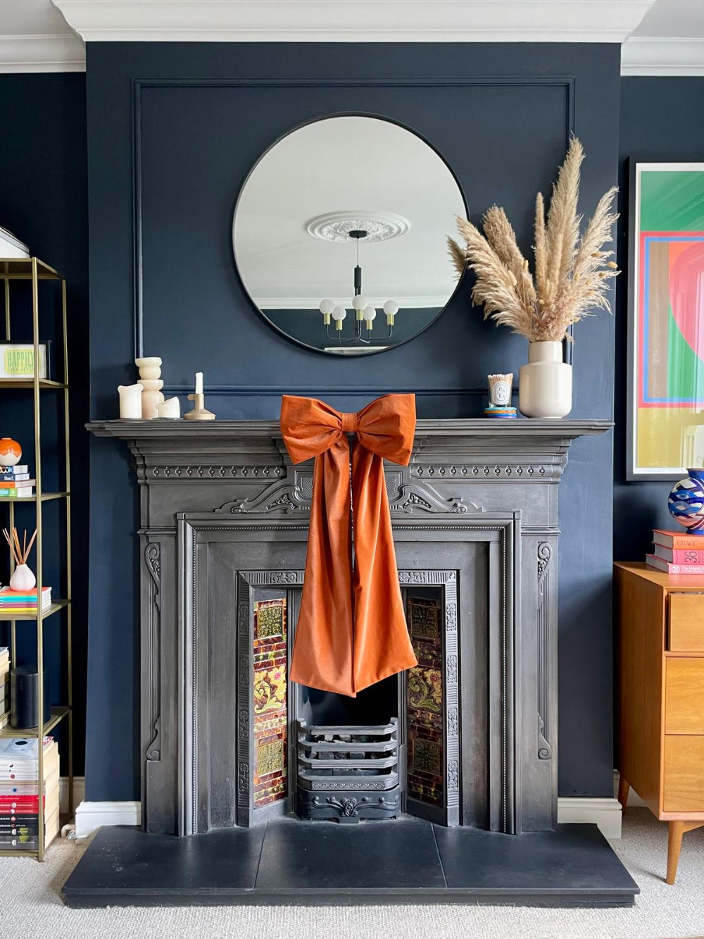 Rust velvet Christmas bow styled on a fireplace mantel