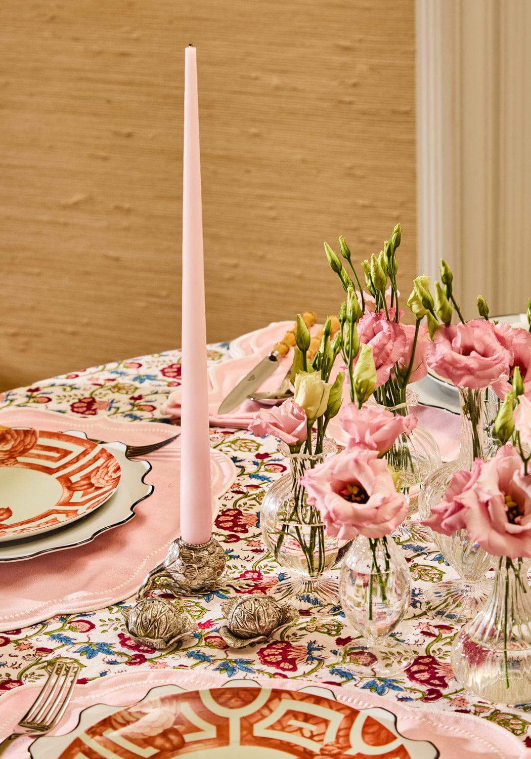 Decorative table setting with pink candles, floral arrangements, and patterned tablecloth with cabbage pewter salt and pepper shakers