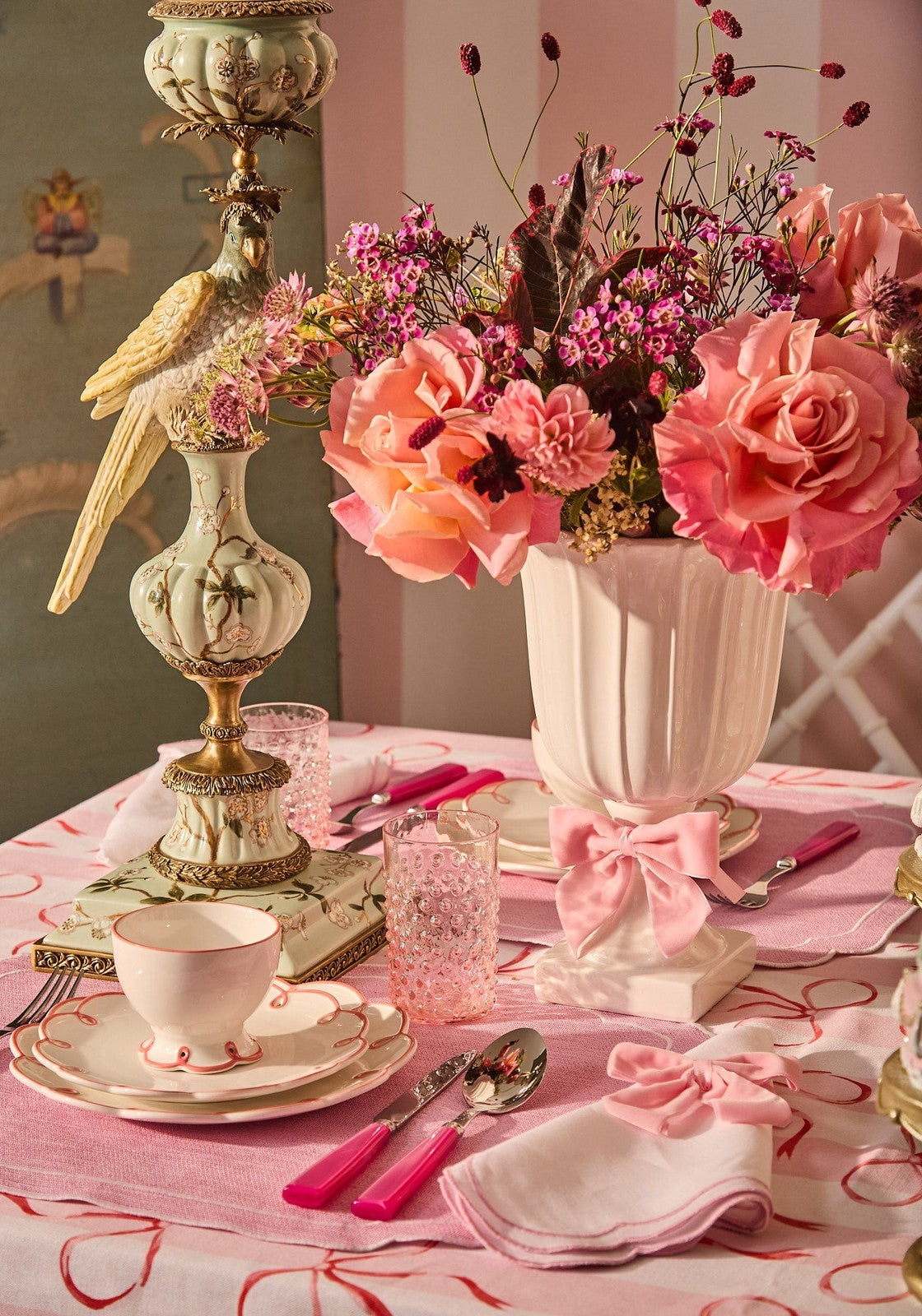 Decorative table setting with flowers, teacup, and pink accents.