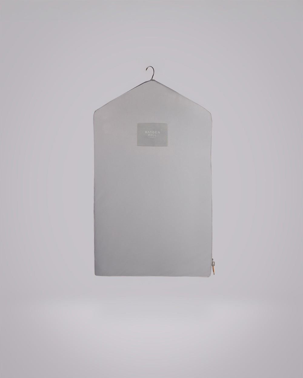 A light grey zippered garment cover or dust bag hanging on a small metal hanger against a plain light grey background.