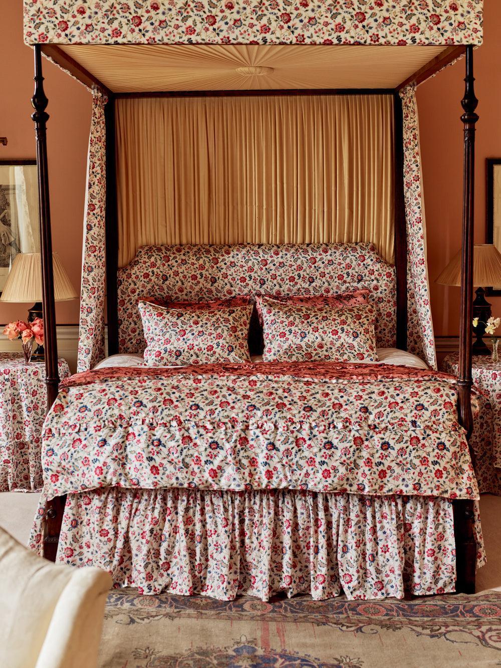 Floral canopy bed in a bedroom setting with matching bedding and curtains.