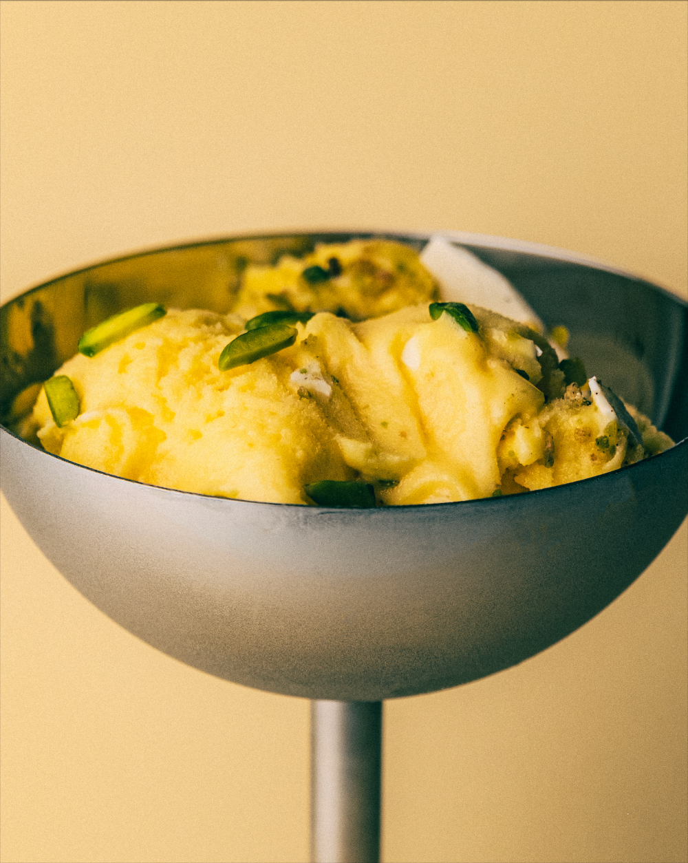 Dessert bowl with ice cream against a yellow background