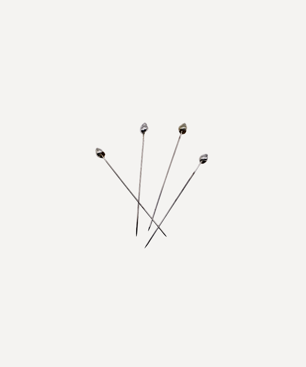 Set of four shell cocktail sticks on a white background