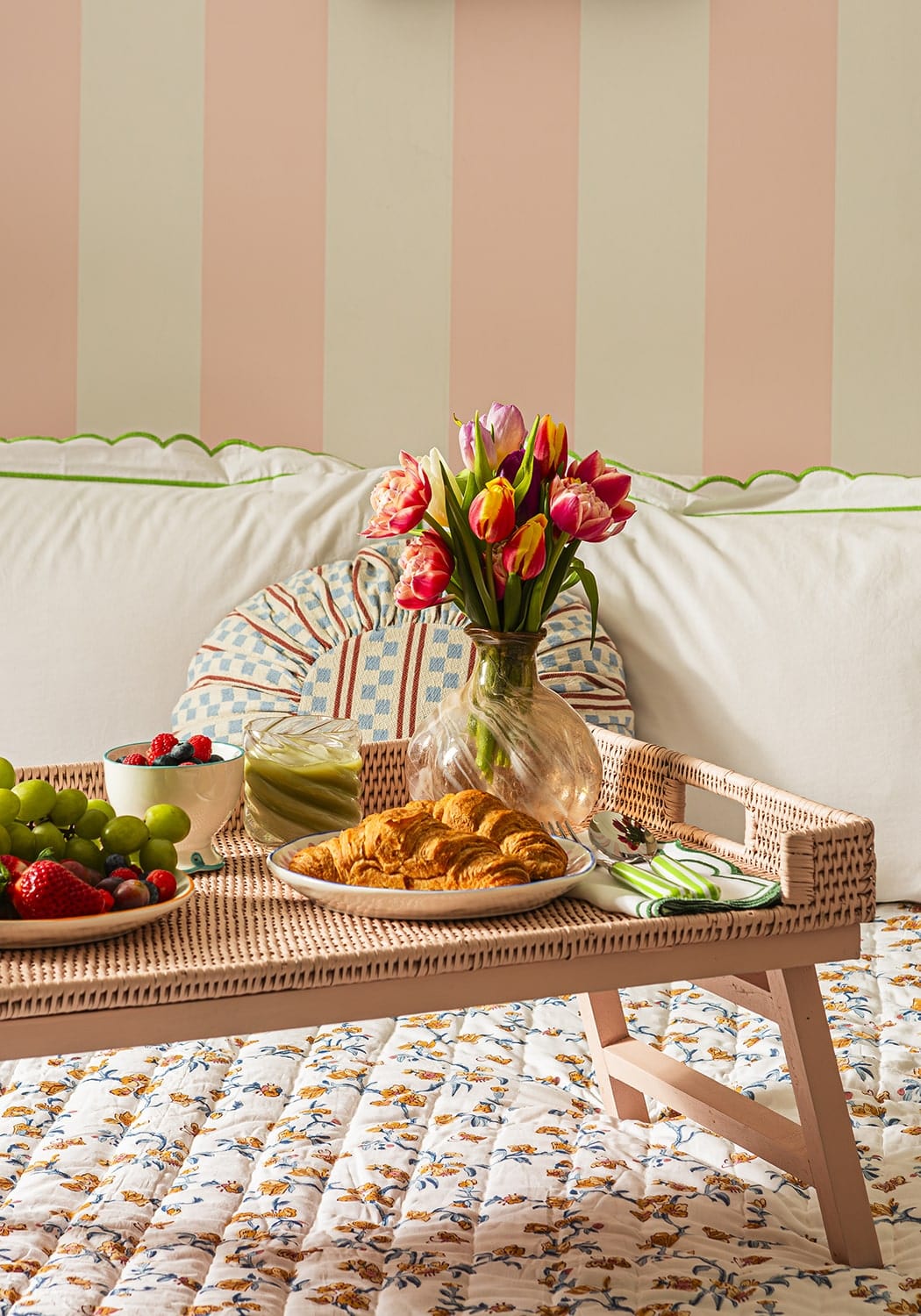 Table with picky bit snacks and flowers against a striped wall