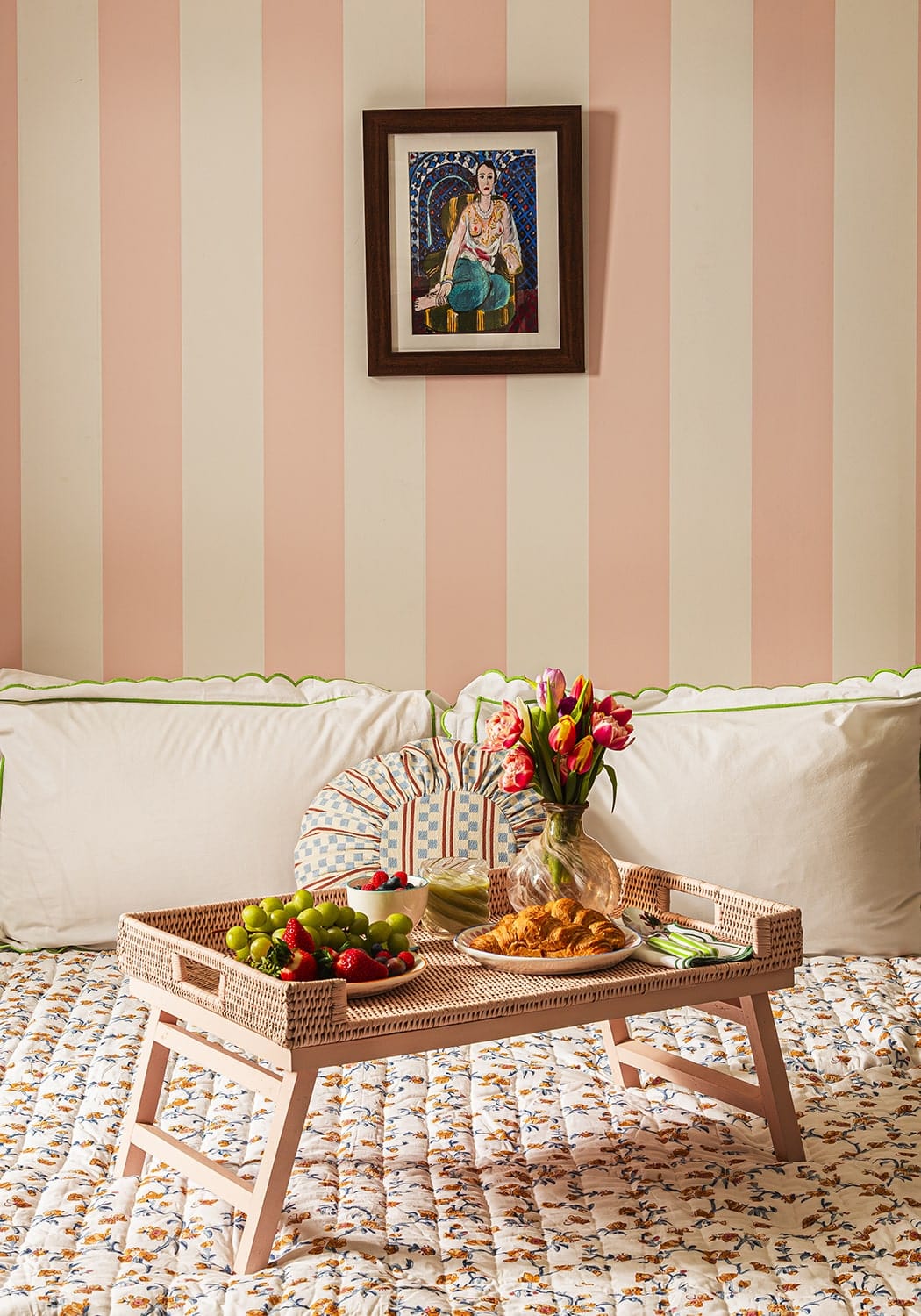 Living room with striped wallpaper, a sofa, and a small table with nibbles food and flowers.