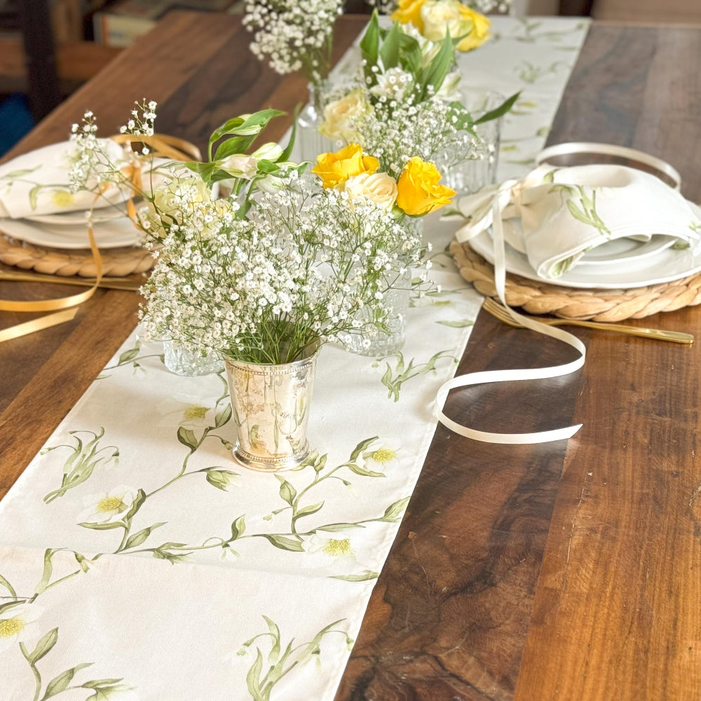 Decorative table setting with floral centrepieces on a wooden table.