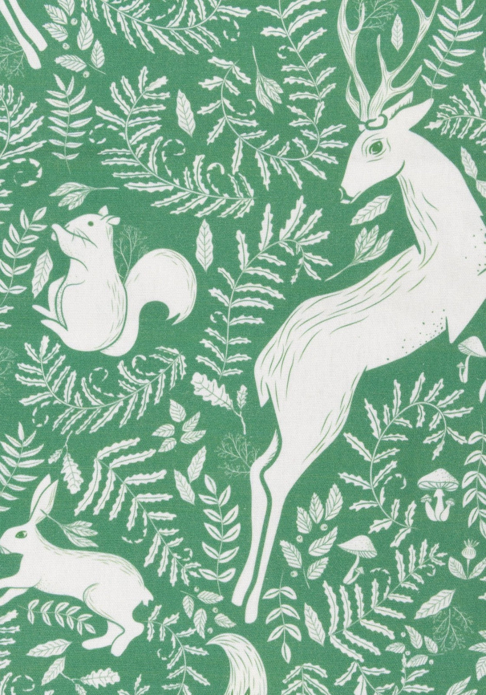 White forest animals and foliage patterned tablecloth on a green background
