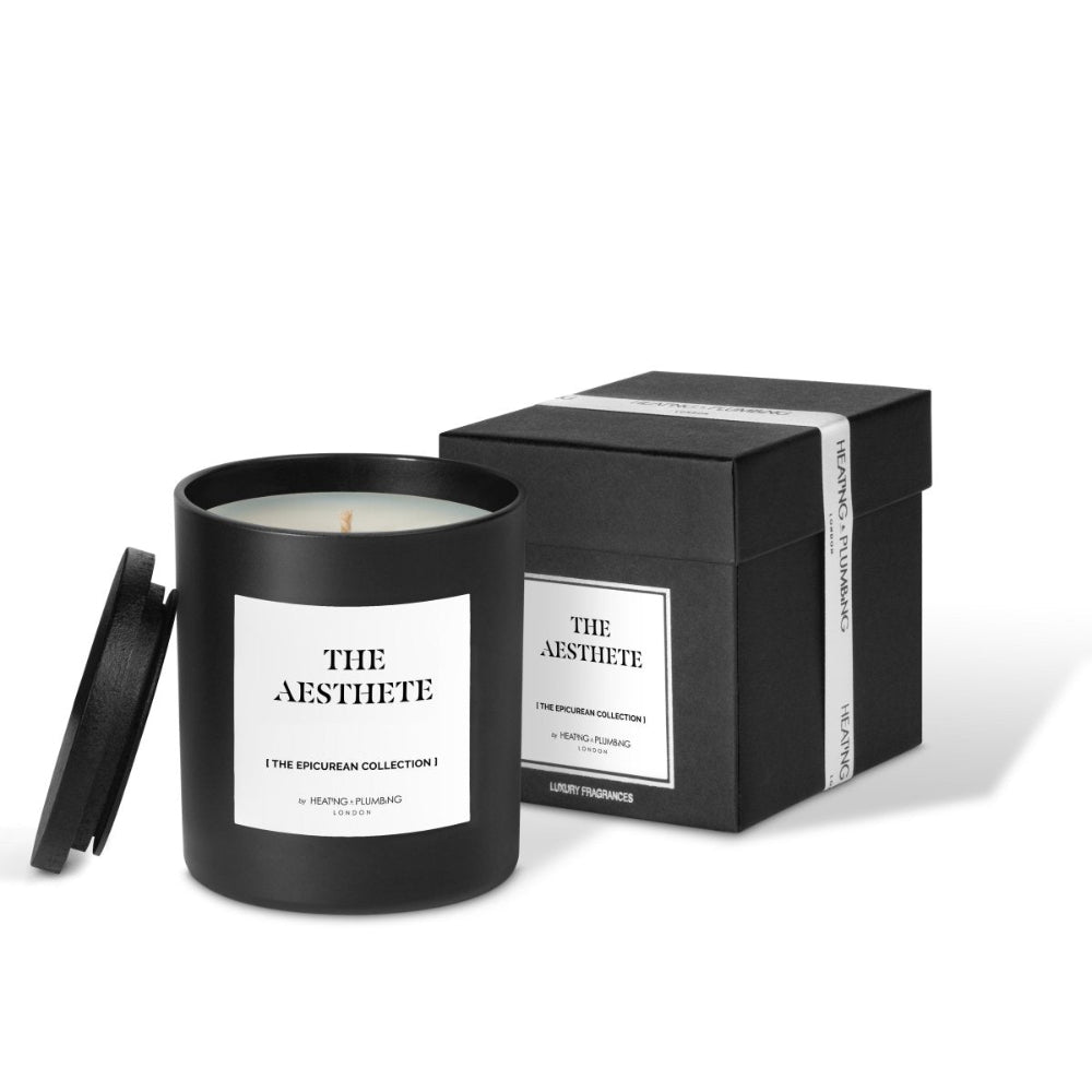 Black candle with white label and matching black box on a white background
