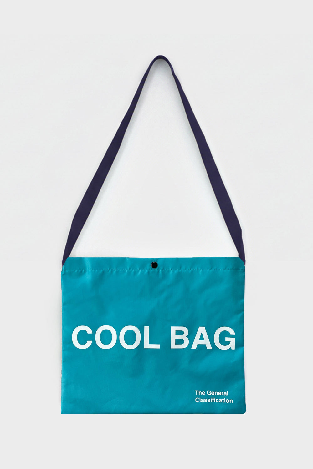 A teal tote bag with dark navy straps and white printed text reading 'COOL BAG' and 'The General Classification' on a light grey background.