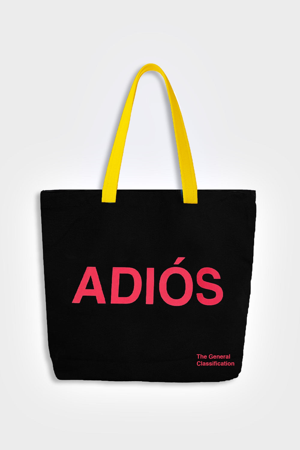 Black tote bag with pink 'ADIOS' text and yellow handles on a light gray background