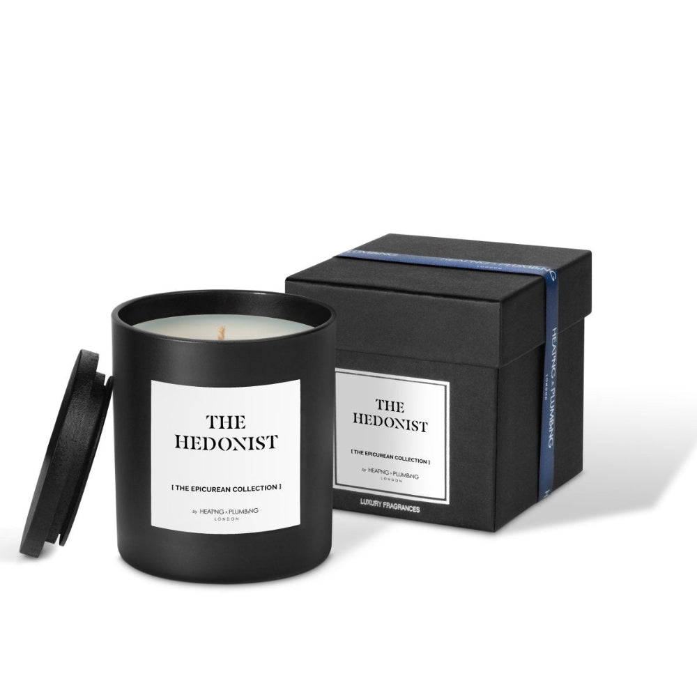 Candle with 'The Hedonist' label and packaging on a white background