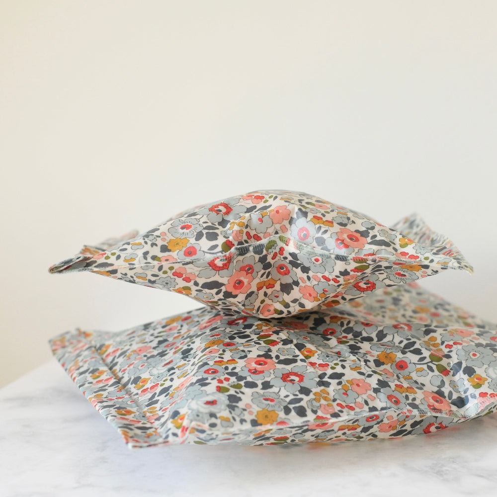 Floral patterned stacked beeswax food storage bags on a white background