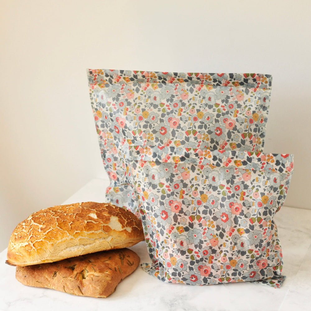 Floral-patterned reusable bag with bread on a white surface