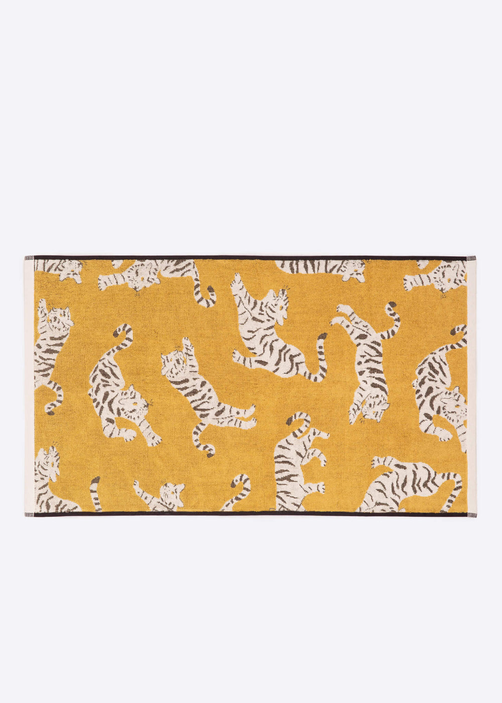 Yellow bath towel with white tiger pattern on a white background