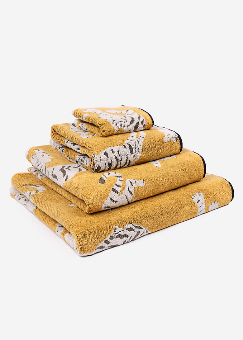 Set of yellow towels with tiger pattern on a white background