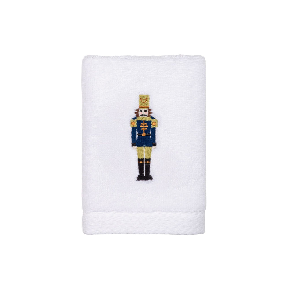 White towel with a embroidered green nutcracker design on a white background