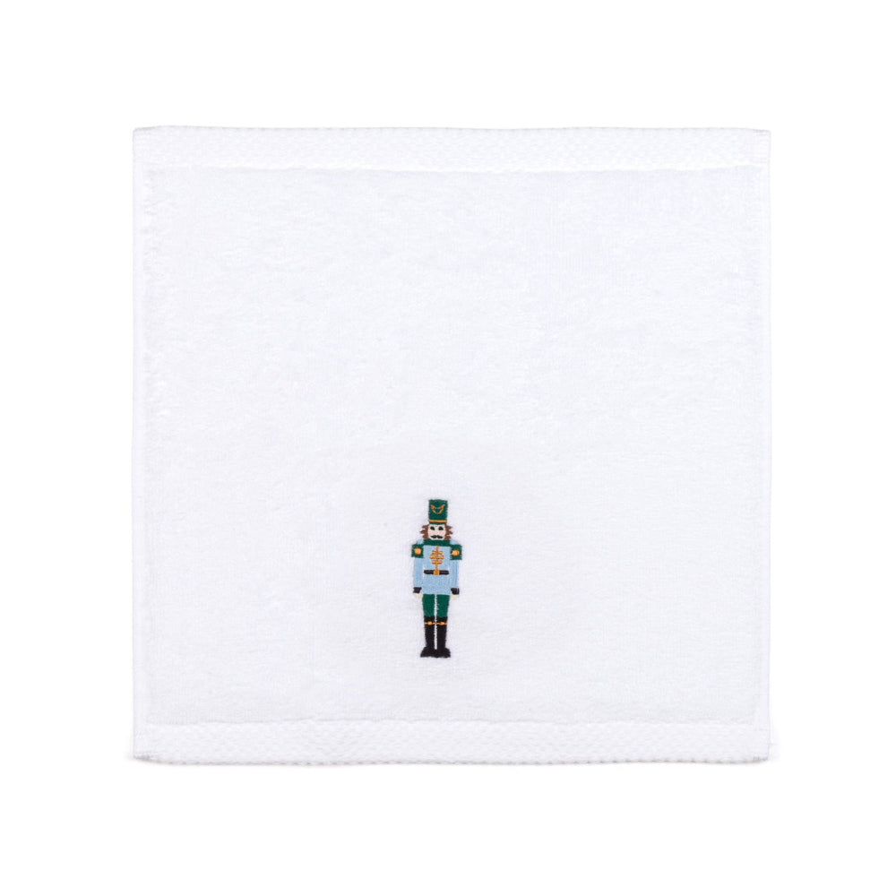 White face towel with a embroidered nutcracker design on a white background