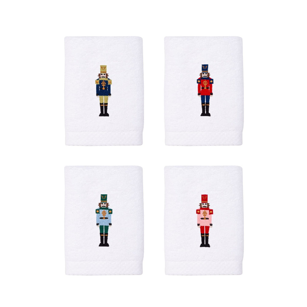 Four white hand towels with embroidered nutcracker designs on a white background