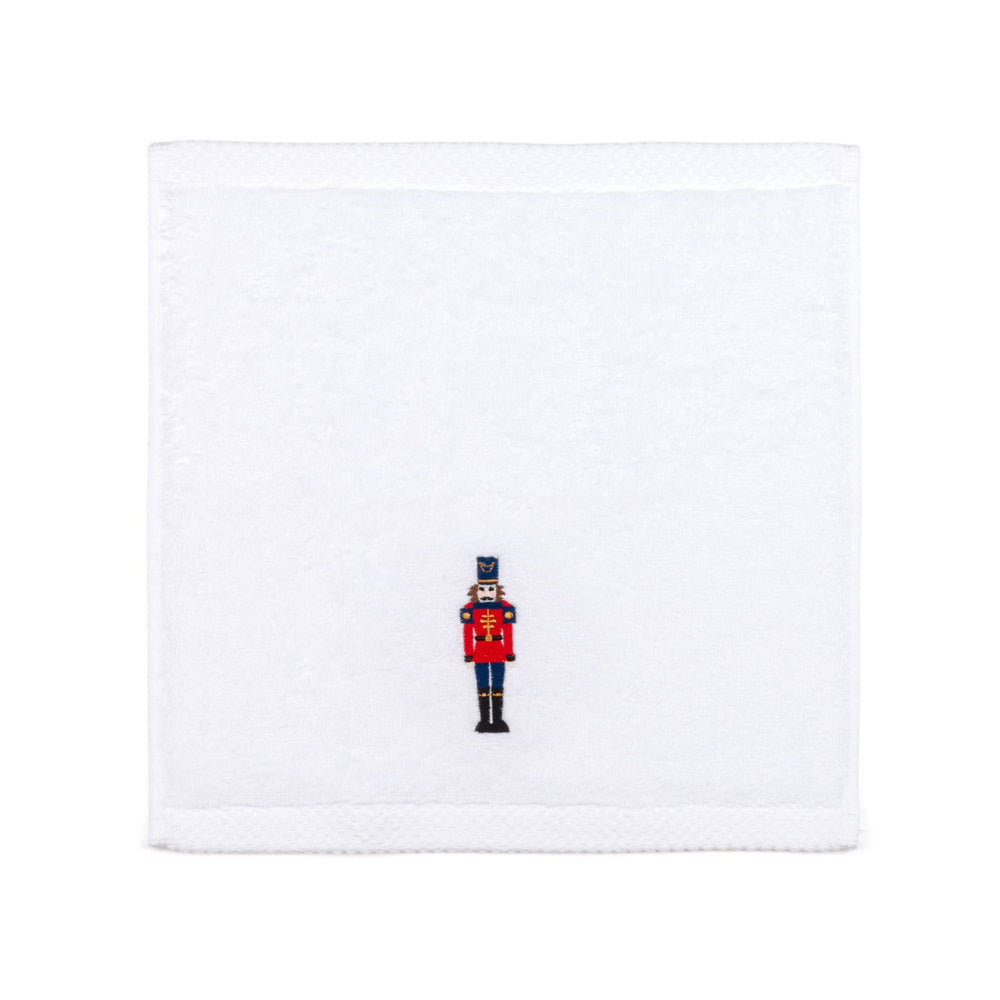 White face cloth with a embroidered nutcracker design on a white background
