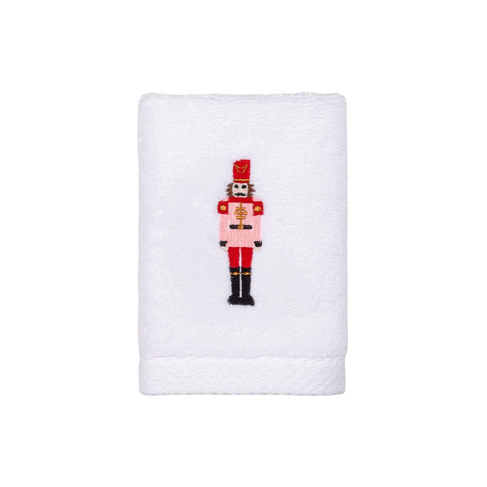 White towel with a embroidered pink nutcracker design on a white background