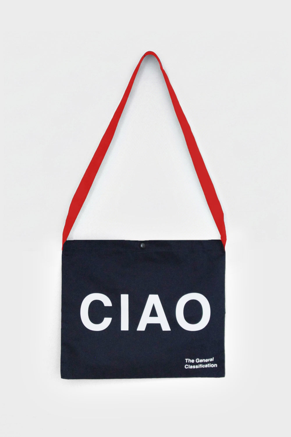 Black tote bag with 'CIAO' text and red strap on a light grey background
