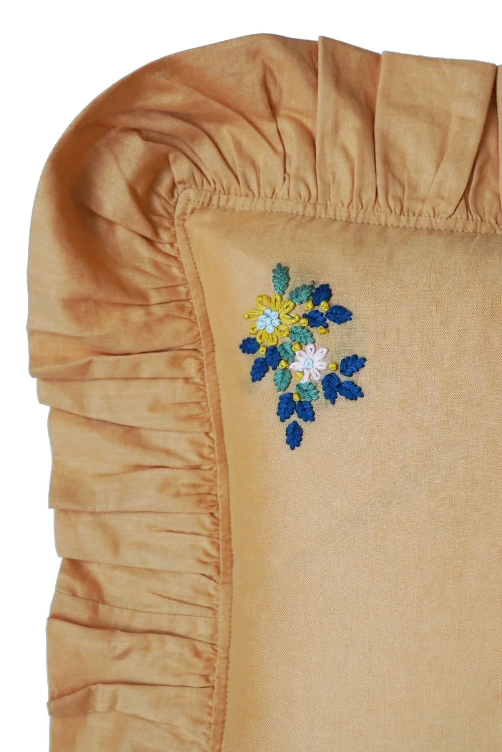 Tumeric fabric with floral embroidery on a white background