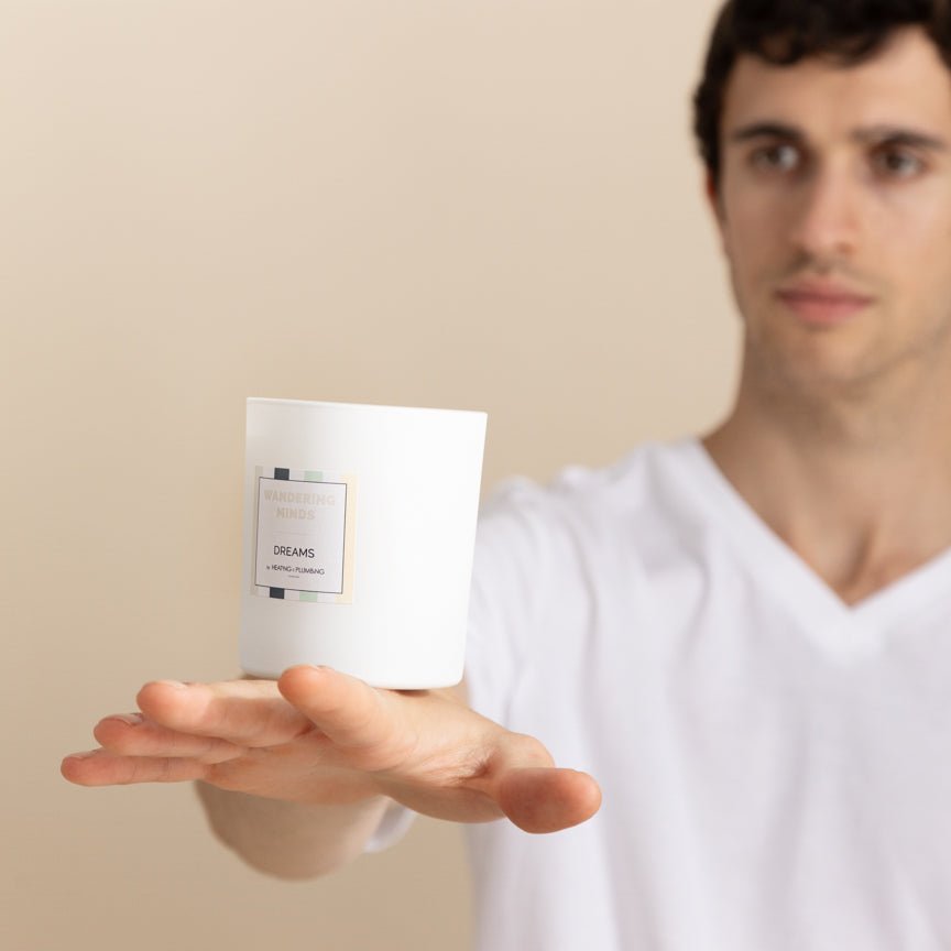 Man holding a candle with a label on a beige background