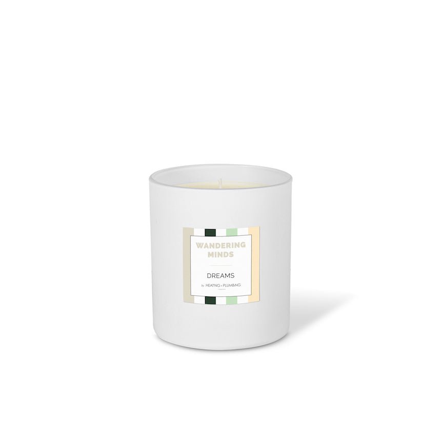 White candle with a label wandering minds on a white background