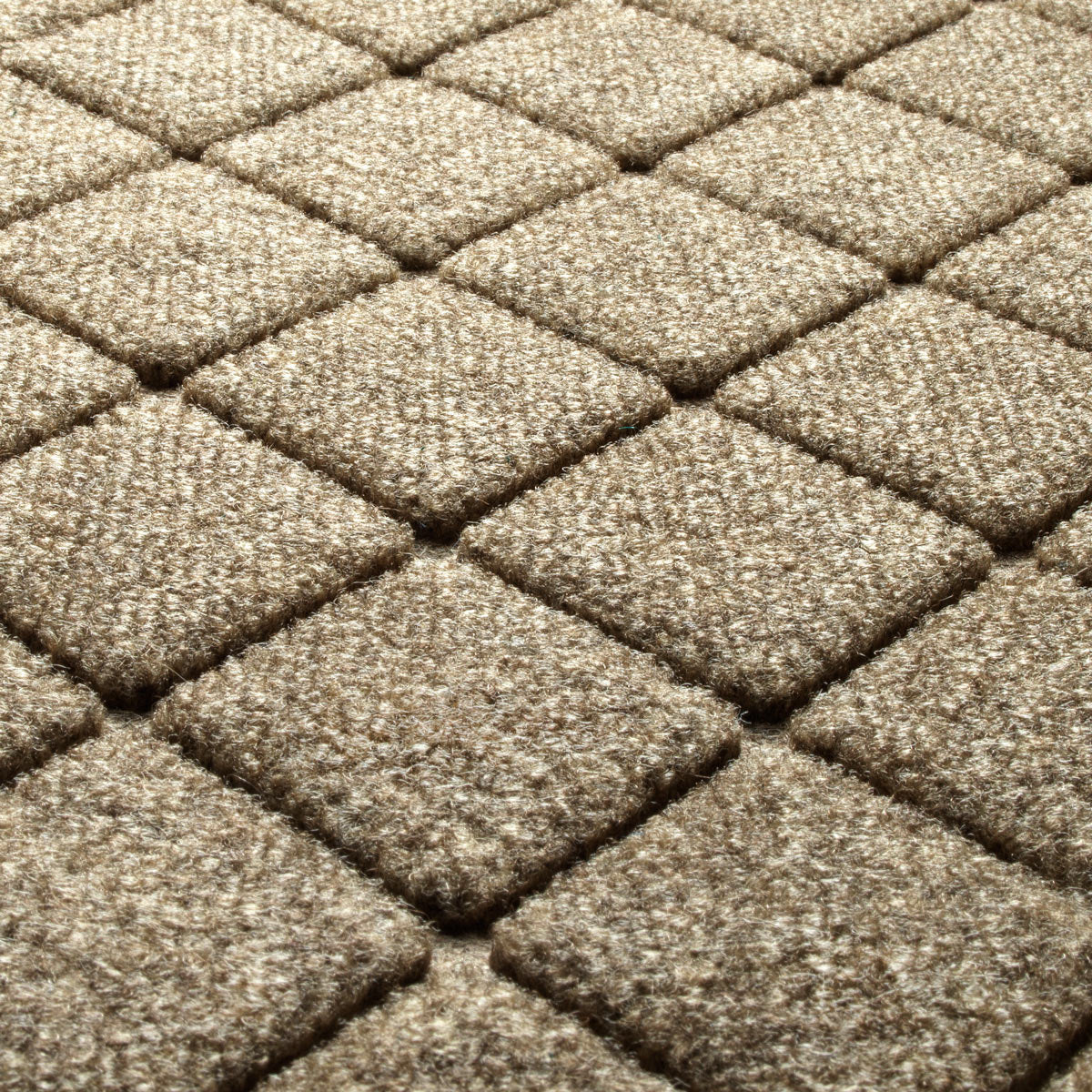 Close-up of the Camel WaterHog Argyle doormat showing raised diamond-shaped fibres and recessed dirt-trapping grooves.