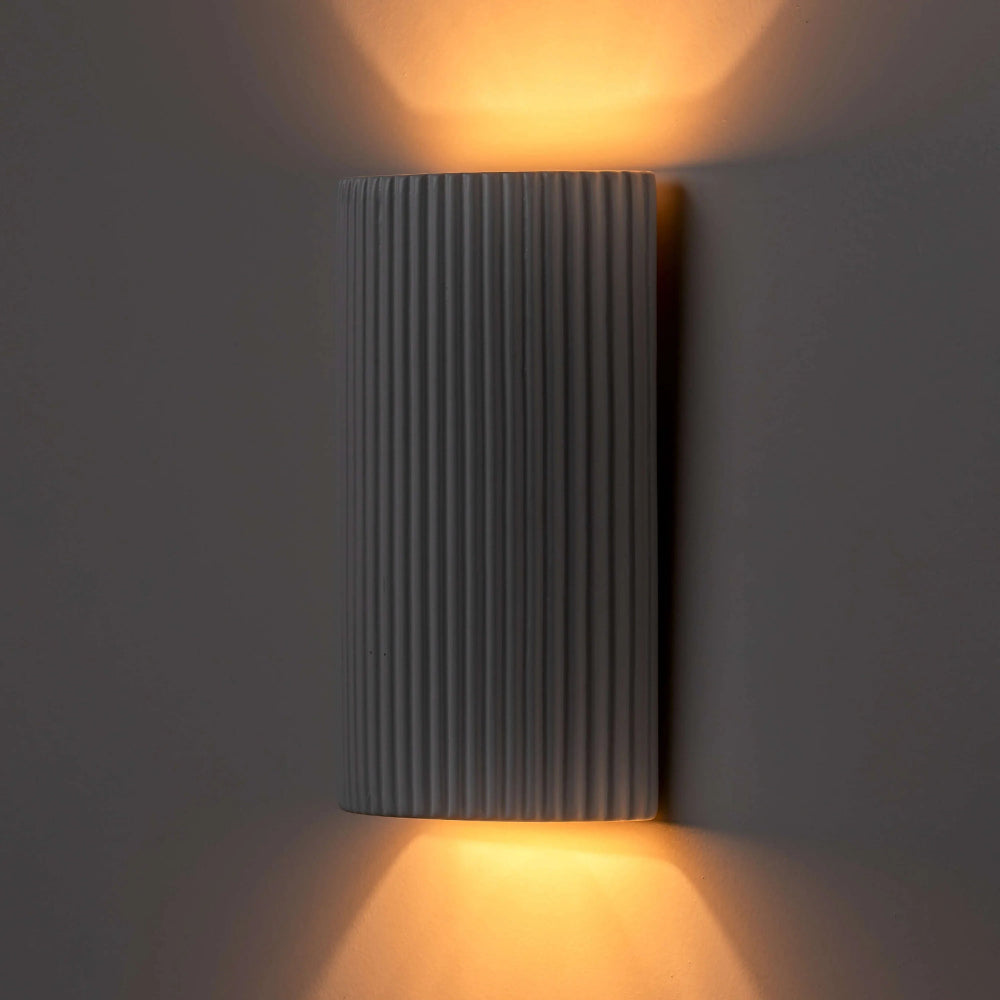 Side view of white ceramic wall light showing its slim depth