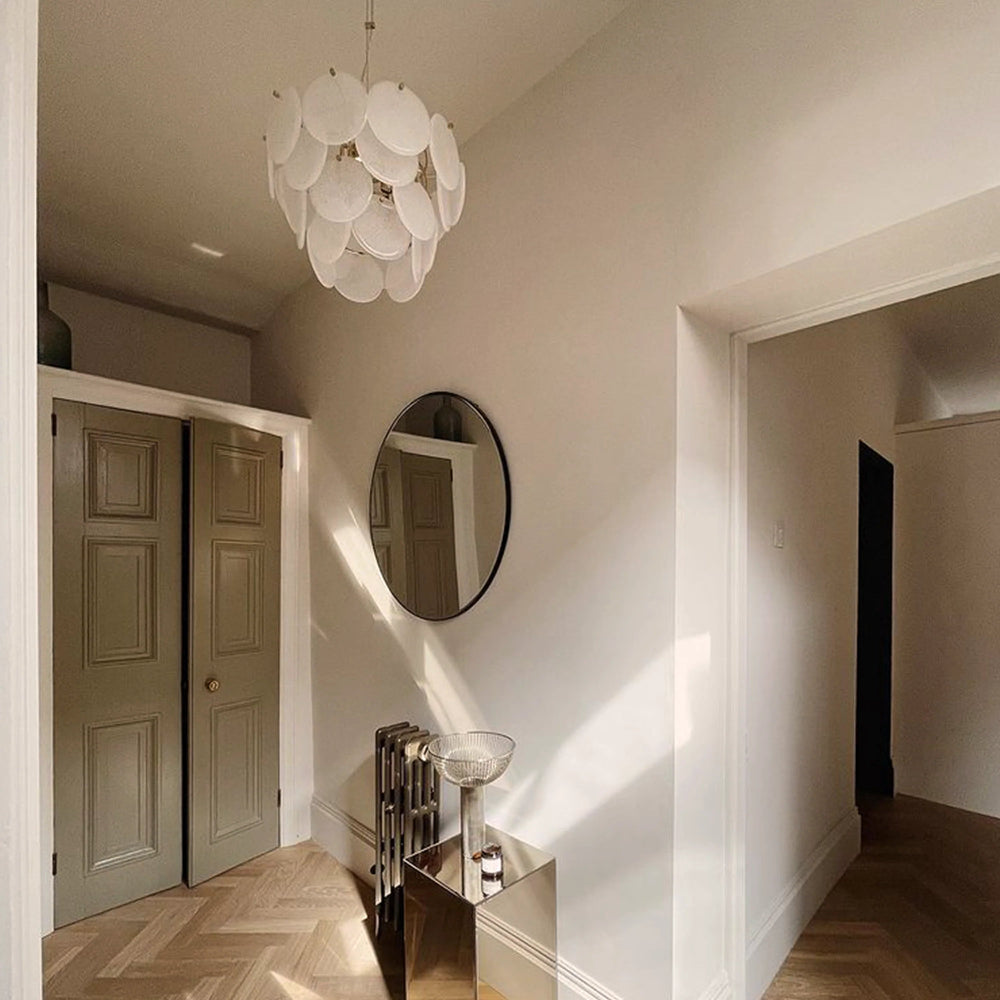 White glass chandelier used as a statement light in a hallway