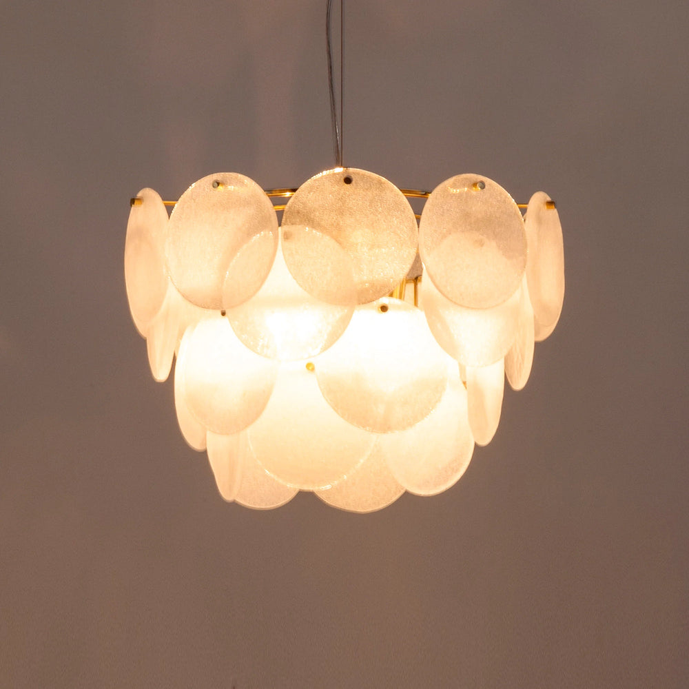 Front view of white glass chandelier lit with layered frosted glass discs
