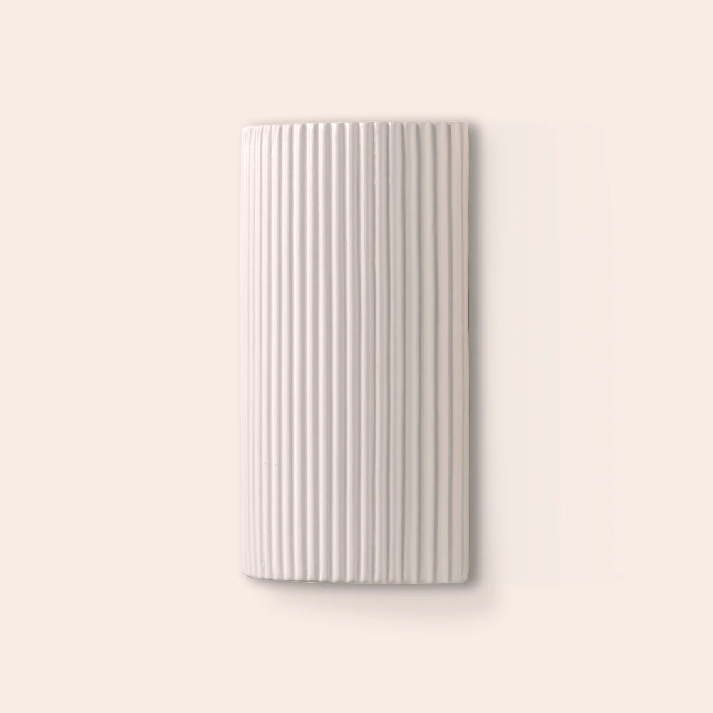Rectangular white wall light with a ribbed texture on a light beige background