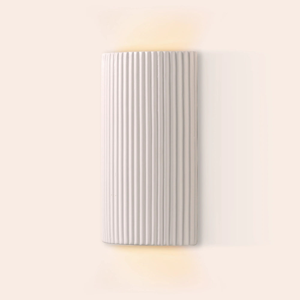 White wall light switched on with an up and down glow