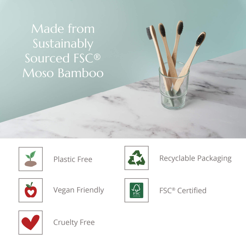 Bamboo toothbrushes in a glass on a marble surface with sustainability certification icons below.
