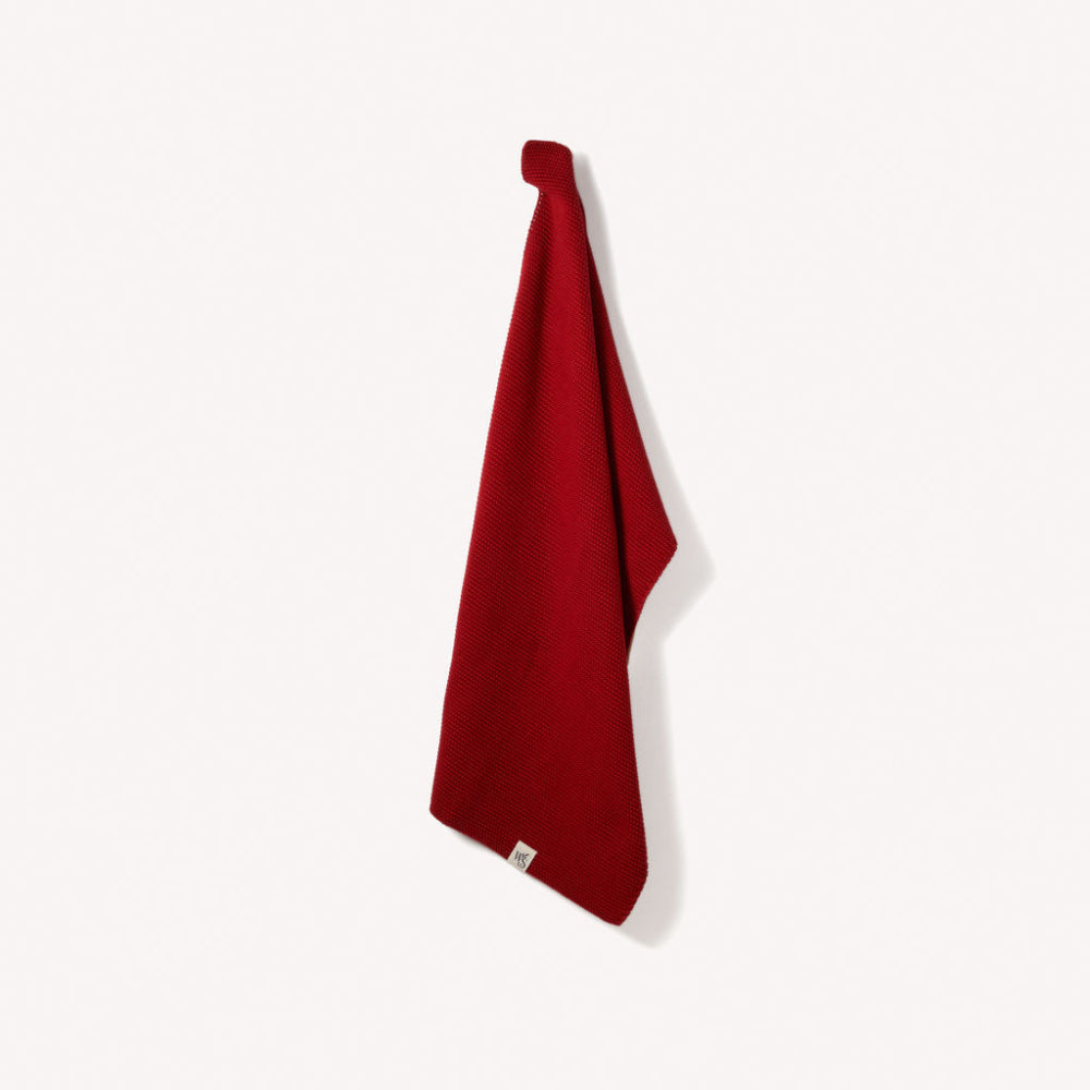 Red berry organic hand towel hanging on a white background