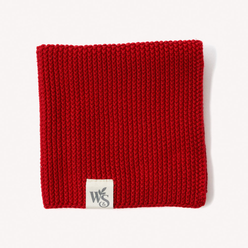 Berrry Red knitted organic dishcloth with a logo tag on a white background